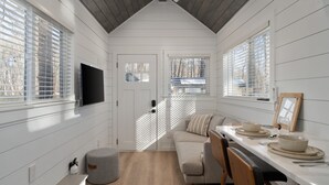 Eine moderne Küche mit Essbereich, Holzboden und großen Fenstern.
