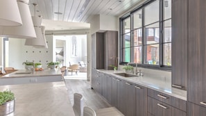 A modern kitchen with dark wood cabinets, a large window, and a dining area with a view.