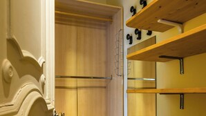 Ein Zimmer mit Holzboden, einer Tür mit aufwendiger Verzierung und eingebauten Holzregalen.