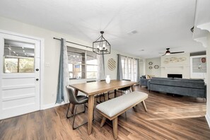 Cozy living area with a dining table, comfortable seating, and a stylish chandelier.