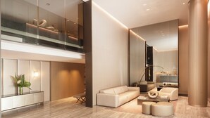 A modern living room with a sofa, ottoman, and a glass railing overlooking a lower level. - Incredible Studio Luxe Tower D902 (Buenos Aires)