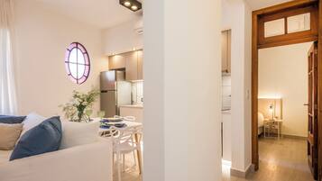 Apartamento Deluxe, vistas al patio | Zona de estar | Una televisión de pantalla plana