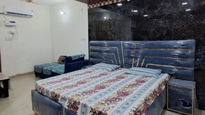 Un dormitorio con una cama grande, una cama más pequeña, un ventilador de techo y una pared de mármol.