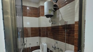 Un baño con inodoro, bidé, lavamanos y zona de ducha.
