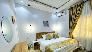 Een hotelkamer met een bed, nachtkastje en bureau.