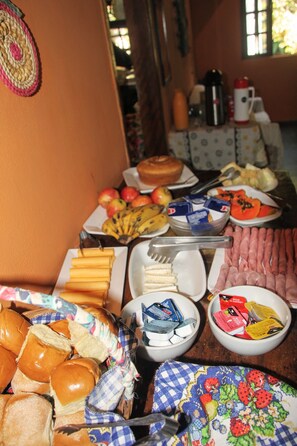 Un tavolo del buffet con diversi cibi, tra cui frutta, pasticcini e condimenti.