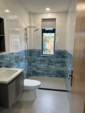 A modern bathroom with a shower, toilet, and bathtub.