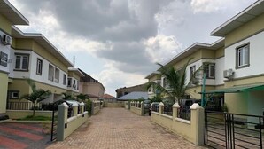 Zona residencial con un sendero pavimentado, casas con balcones y cielo despejado.