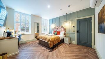 A bedroom with a bed, bedside tables, a desk, and a chair.
