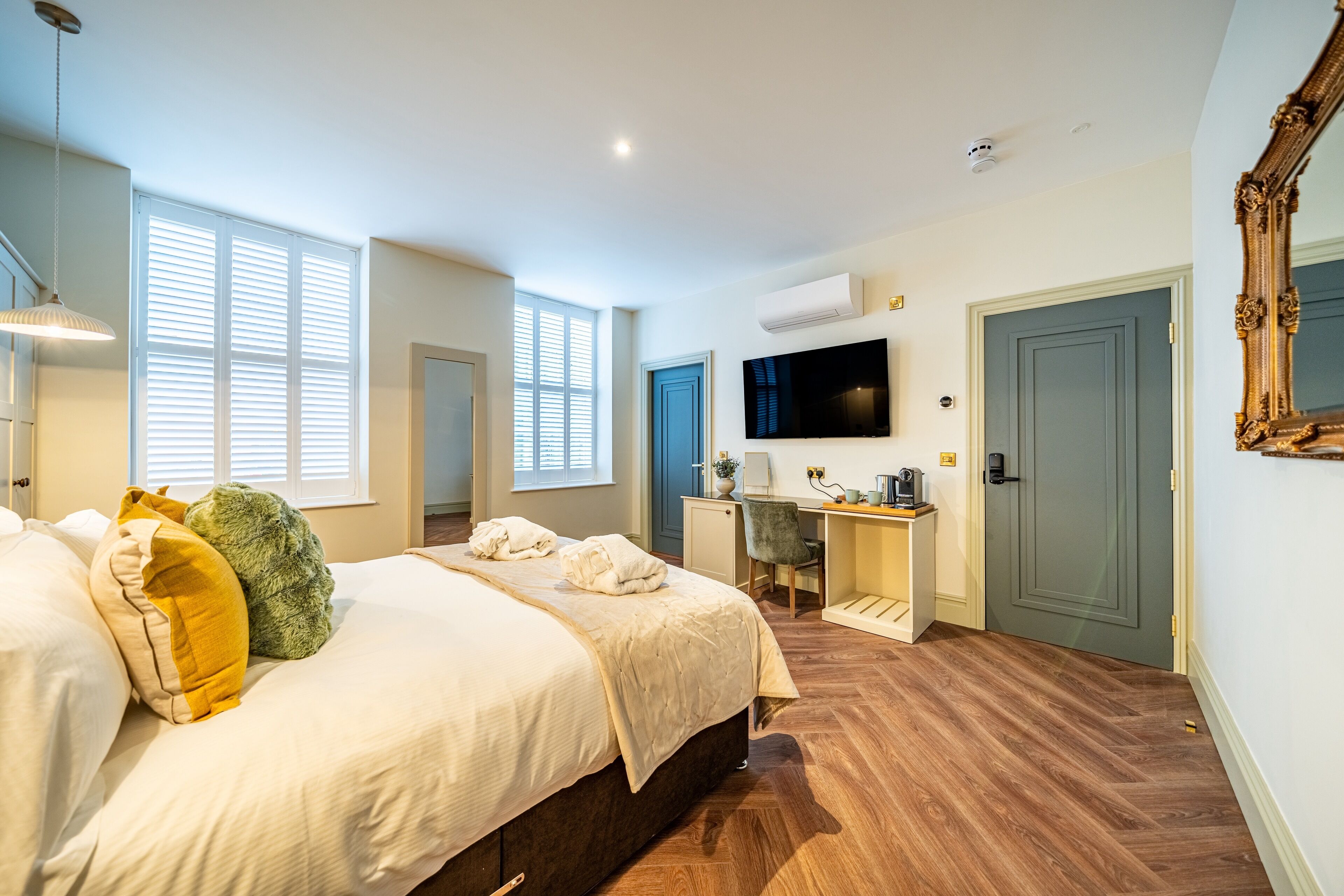 Una camera d'albergo moderna con un letto grande, una scrivania con un computer, una TV e un armadio.