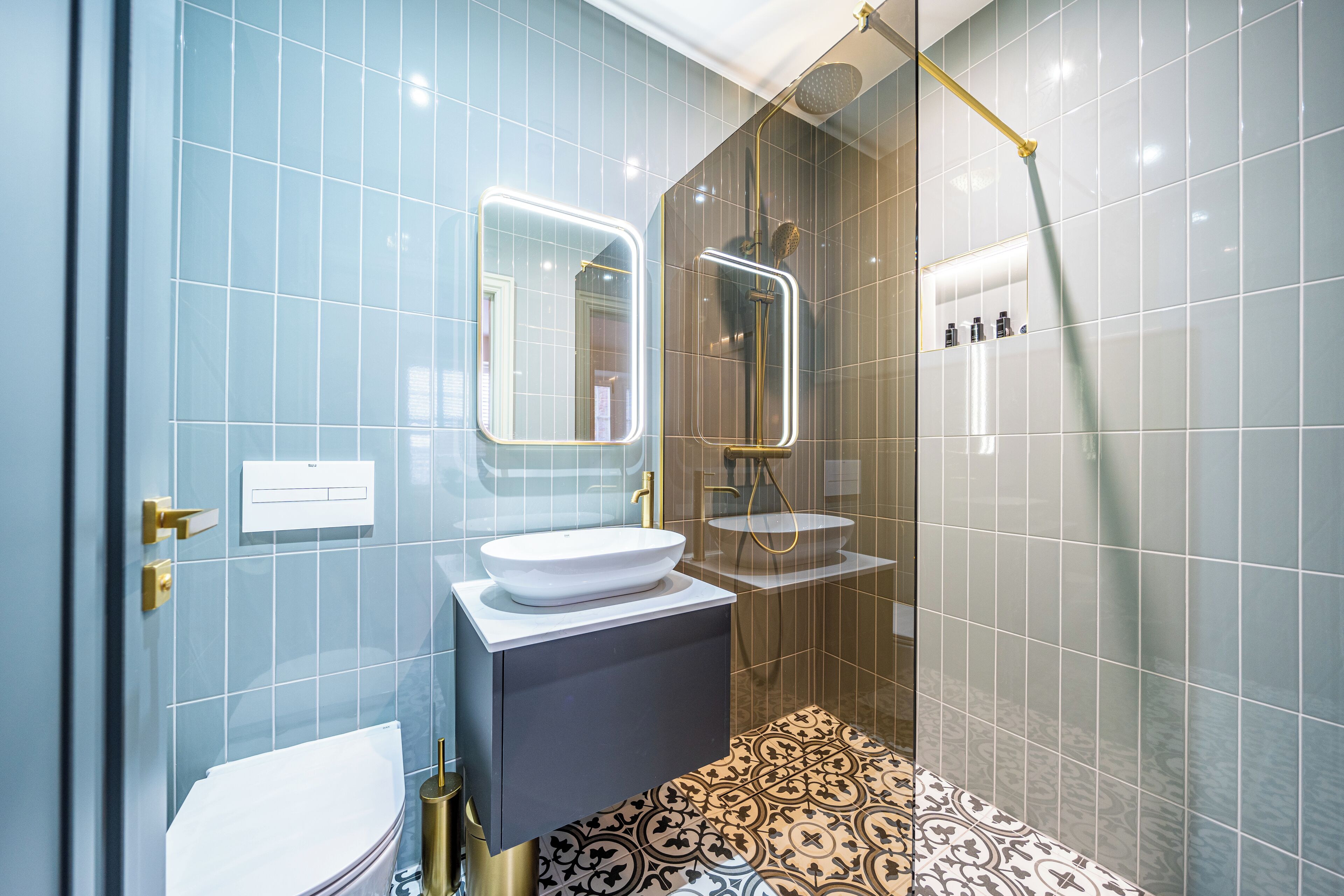A modern bathroom with a toilet, sink, and shower.