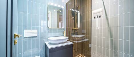 A modern bathroom with a toilet, sink, and shower.
