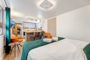 Enjoy a comfortable stay in this stylish room featuring a large bed, kitchenette, and bathroom.