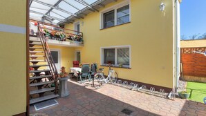 Un edificio giallo con un portico coperto, una scala e un rastrelliera per biciclette.