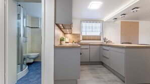 Un bagno moderno con box doccia in vetro, un water e un lavabo con piano.