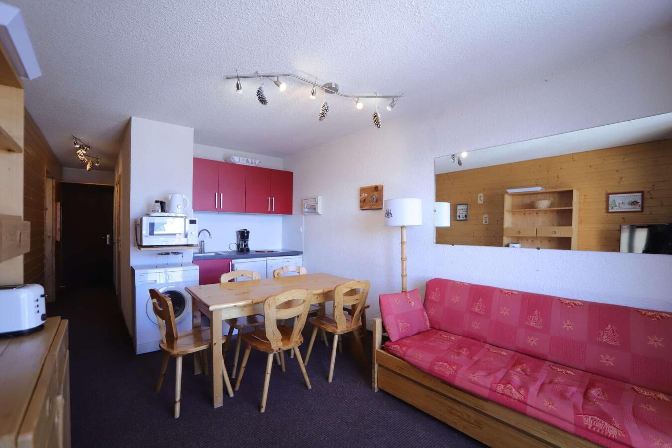 A compact living space with a kitchenette, dining area, and a sofa.