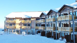 A multi-story hotel with balconies and a snow-covered roof.