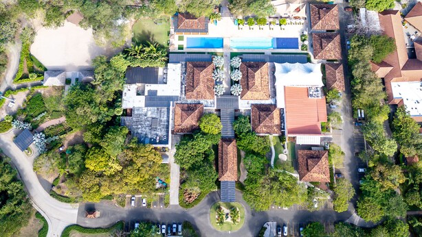 An aerial view of a resort with multiple buildings, a swimming pool, and a beach. - Luxury 4-Bedroom Condo with Stunning Views – Poro 4A (Santa Cruz)