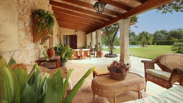 A covered patio with wicker furniture, potted plants, and a view of a landscaped garden. - H2935 Finca Solivelles in Pollenca for 8 persons (Pollenca)