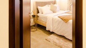 Une chambre à coucher avec un lit, une table de chevet et des miroirs décoratifs sur le mur.