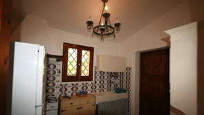 Uma cozinha compacta com geladeira, fogão, pia e armários de madeira.