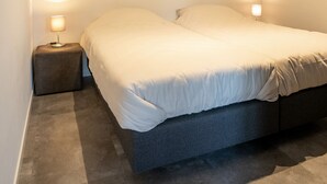 Ein Schlafzimmer mit einem Bett, zwei Nachttischlampen und einem kleinen Nachttisch.