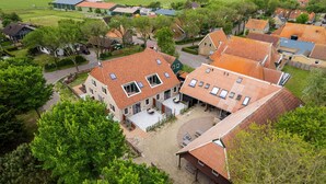 A residential area with houses featuring red-tiled roofs and multiple skylights. - De Witte Brugh - Studio 4 (Buren)