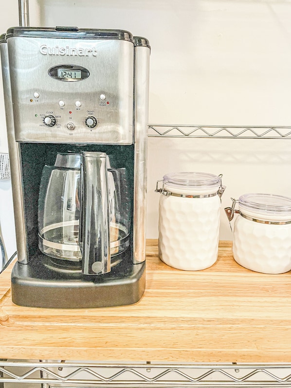 A Cuisinart coffee maker with a digital clock, control panel, and two glass jars on a wooden countertop. - Cozy & Charming 3-bedroom cottage in Springfield - Great Location! Pet friendly! (Springfield)