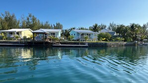 Une propriété située au bord de l’eau, dotée d’un quai, d’un petit bateau et de plusieurs maisons aux toits blancs et aux balcons.