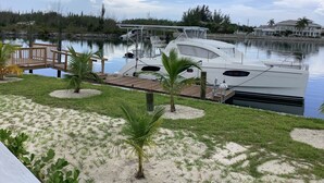 Un port de plaisance avec un quai, un bateau blanc et une jetée en bois.