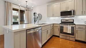 Una cocina moderna con electrodomésticos de acero inoxidable, una isla central y armarios de color claro.