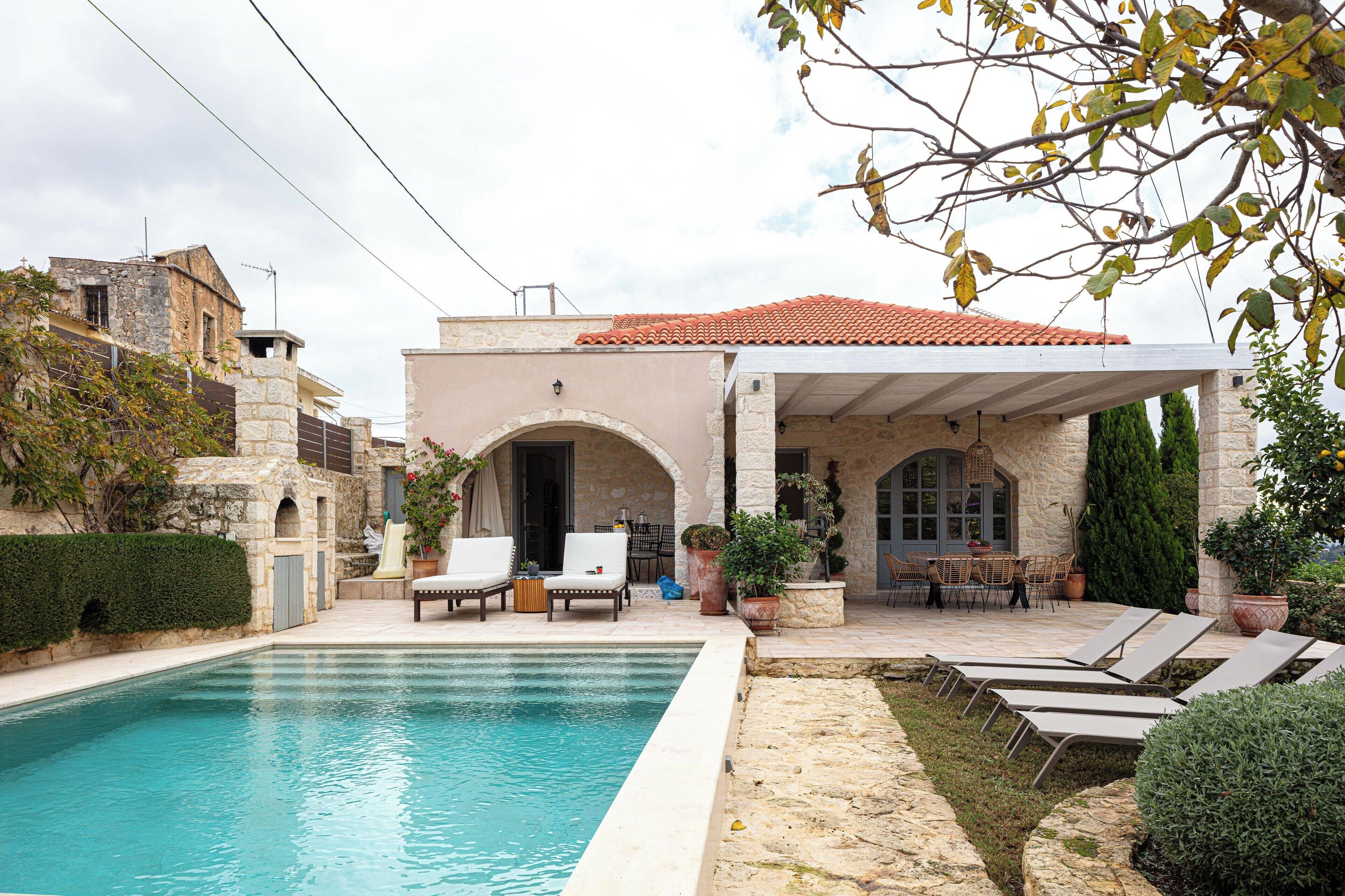Una piscina al aire libre, sombrillas, tumbonas