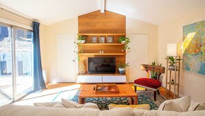 Un salon moderne avec une cheminée, des étagères en bois et une grande fenêtre.