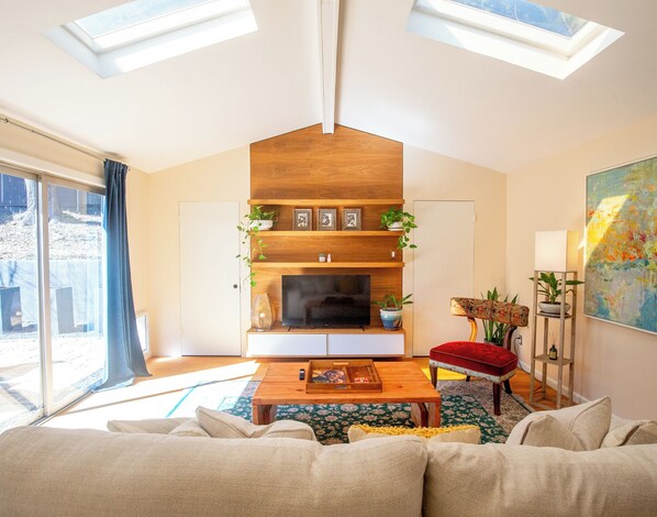 A modern living room with a fireplace, wooden shelves, and a large window. - South Congress Retreat - A Vibey Stay Close to Bars, Shops, Music Venues & Hikes (Austin)