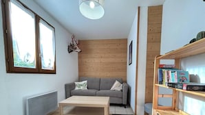 Ein modernes Wohnzimmer mit einer Couch, einem Couchtisch und einem Bücherregal.