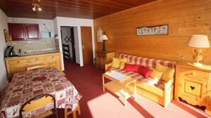 Un interior acogedor de cabaña con comedor, sofá y cocina.
