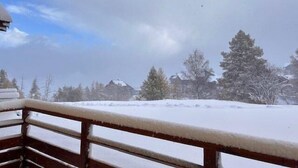 Ein mit Schnee bedeckter Balkon mit Holzgeländer.