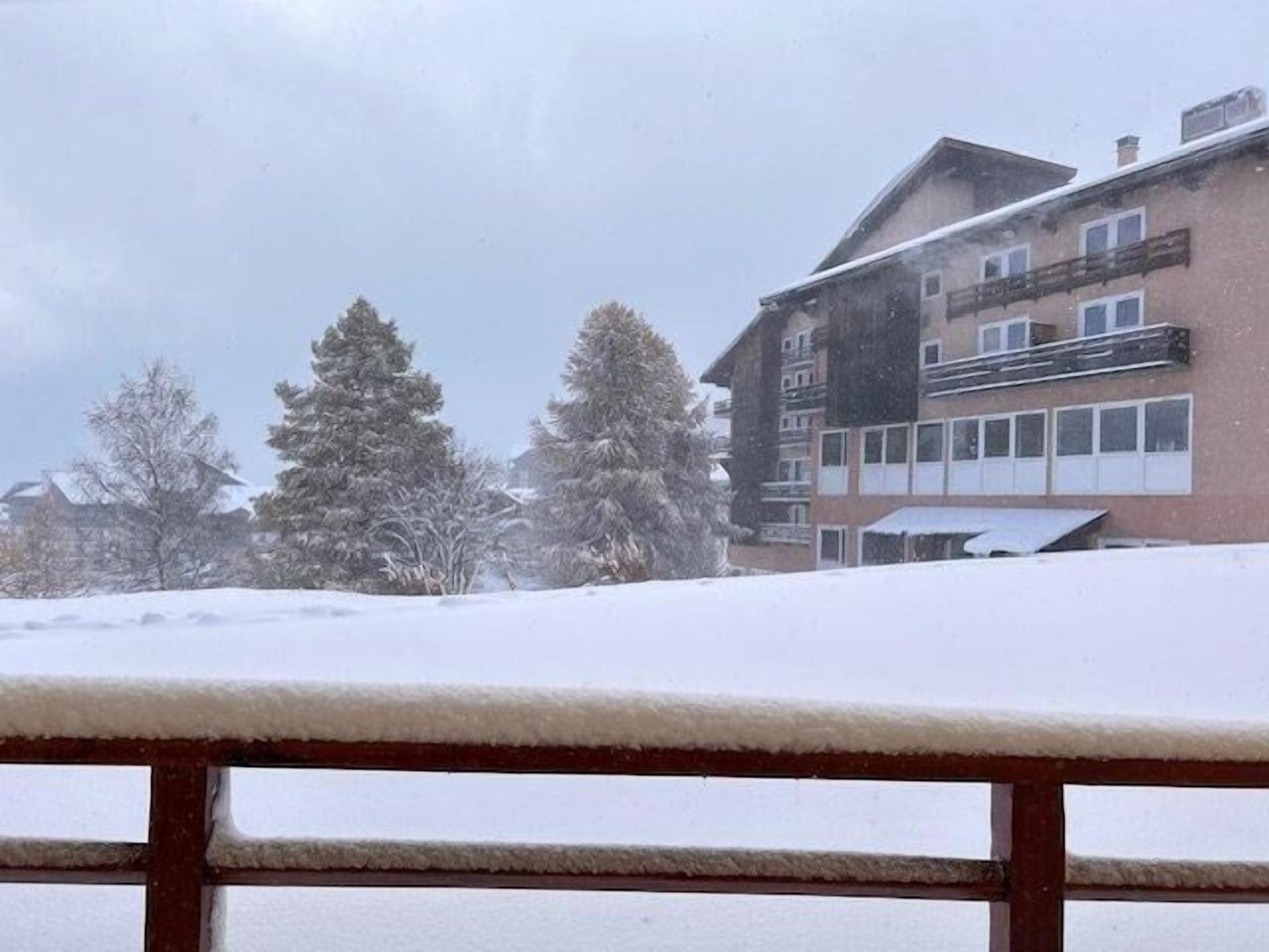 Ett snötäckt landskap med en byggnad som har flera fönster och balkonger.