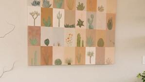 Un canapé marron dans une pièce où est accrochée une grande illustration botanique au mur.