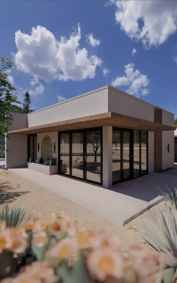 Surrounded by lush greenery, this single-story building features large windows and a minimalist design.