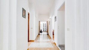 A long, narrow hallway with white walls and a tiled floor. - Elegance&Comfort in Rome-Liberty- (Roma)