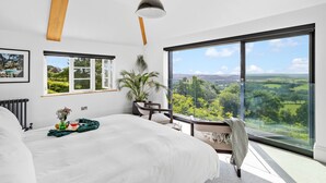 A bedroom with a large bed, a view of the countryside, and a large window. - Fox Hill House in Haytor (Newton Abbot)