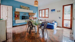 Une cuisine moderne avec une table et des chaises, un four encastré et un mur d’accent bleu.