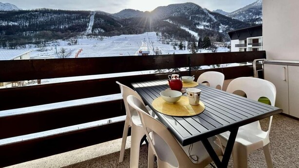 A balcony with a table set for tea, overlooking a snowy mountain landscape. - 4th floor, balcony, tv, 28m², Serre Chevalier (La Salle-les-Alpes)