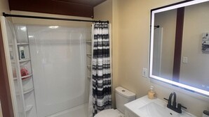 A bathroom with a shower, toilet, vanity, and a mirror. - Charming tiny home only 15 mins from Town of Warrenton & Town of Culpeper (Rixeyville)