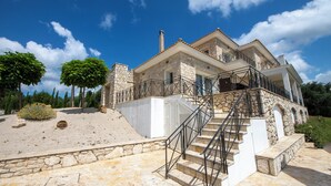 Una casa de piedra con una escalera de piedra y barandilla de metal.