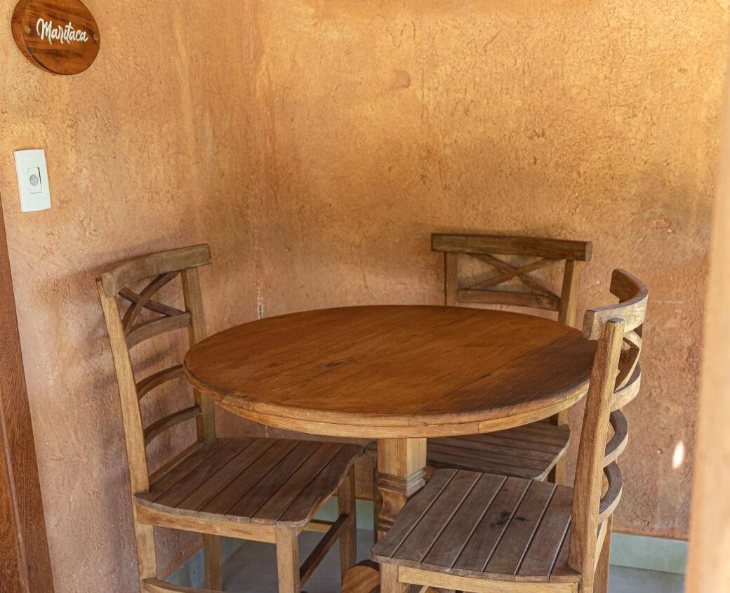 Una mesa redonda de madera con cuatro sillas, cada una con respaldo curvo.