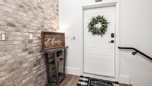A white door with a wreath, a sign above it, and a doormat. - Downtown Boise, BSU, Adventures! (Boise)