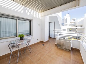 Enjoy the view from this balcony with a table for two and a comfortable seating area.