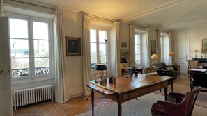 Work, unwind, and enjoy the view from this well-appointed room with a central desk, comfortable seating area, and large windows.